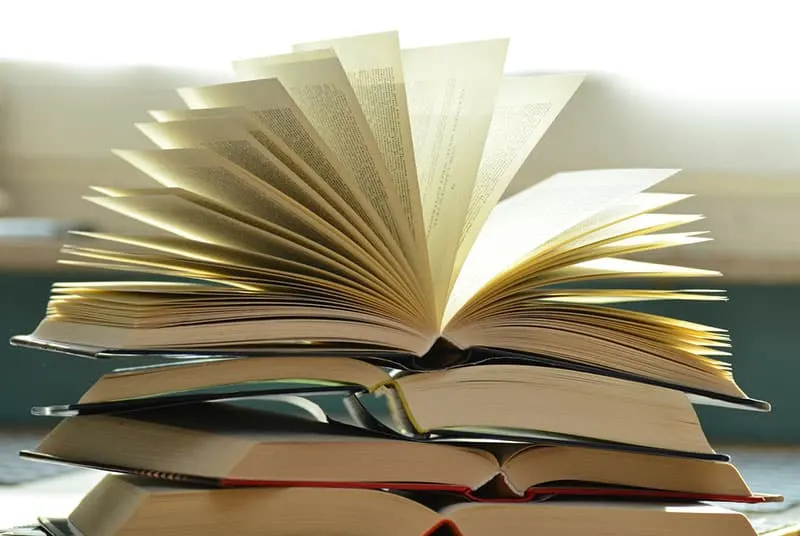 pile of books with one book open