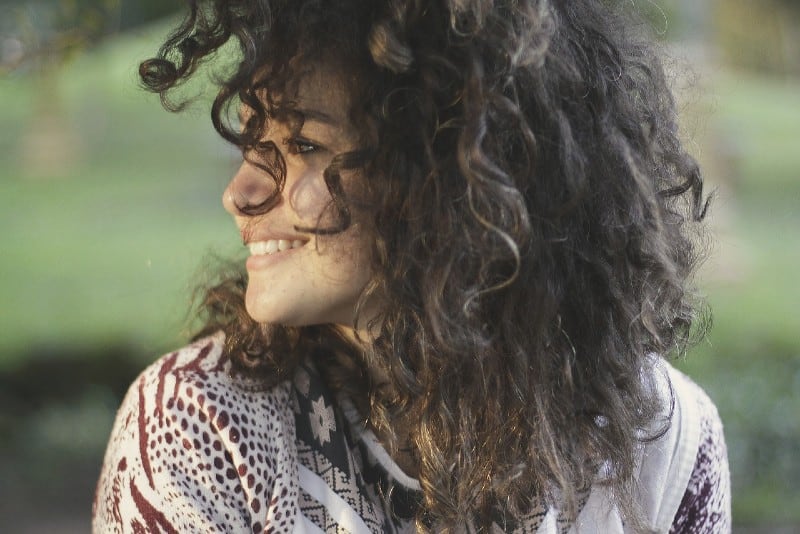 young curly haired woman smiling
