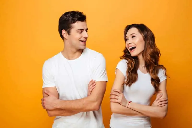 portrait of young couple looking at each other with crossed arms