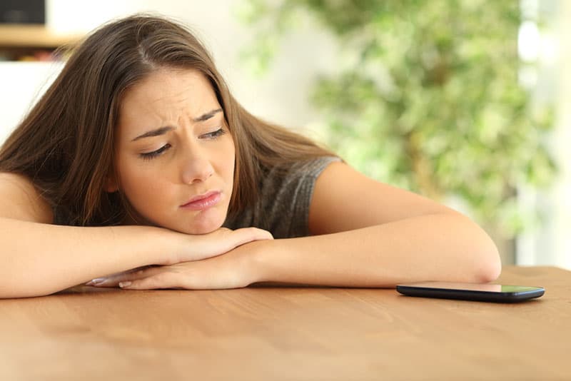 ragazza triste in attesa di una telefonata