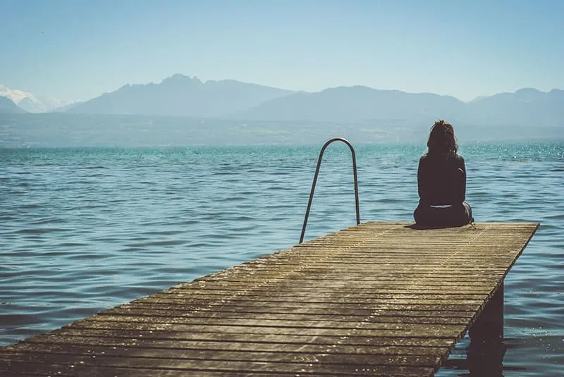 sad woman sitting by the sea