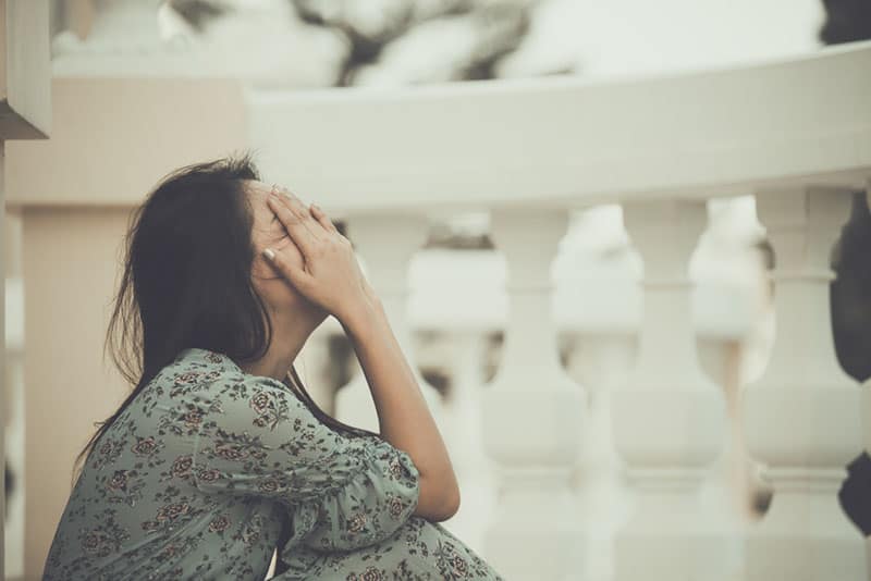 mulher triste sentada no chão e a chorar