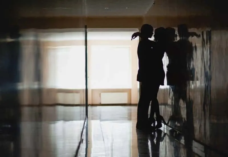 silhouette of couple hugging indoors