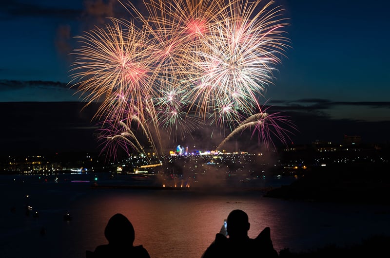 silhouette of two person takingp photo of fireworks