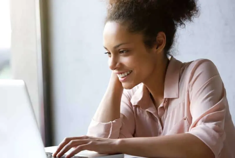 smiling woman looking at laptop screen