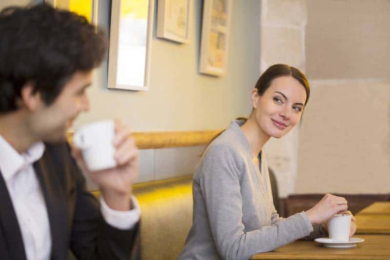 donna sorridente che guarda un uomo in un caffè