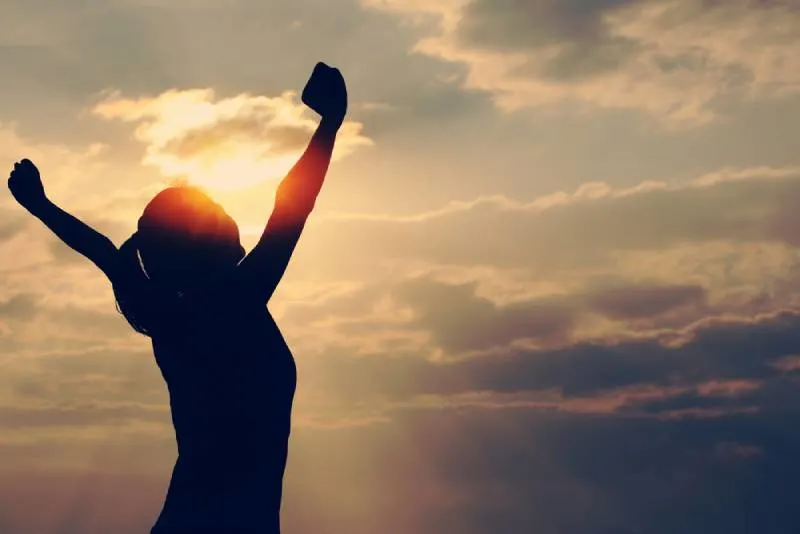 strong woman with hands up to the sky