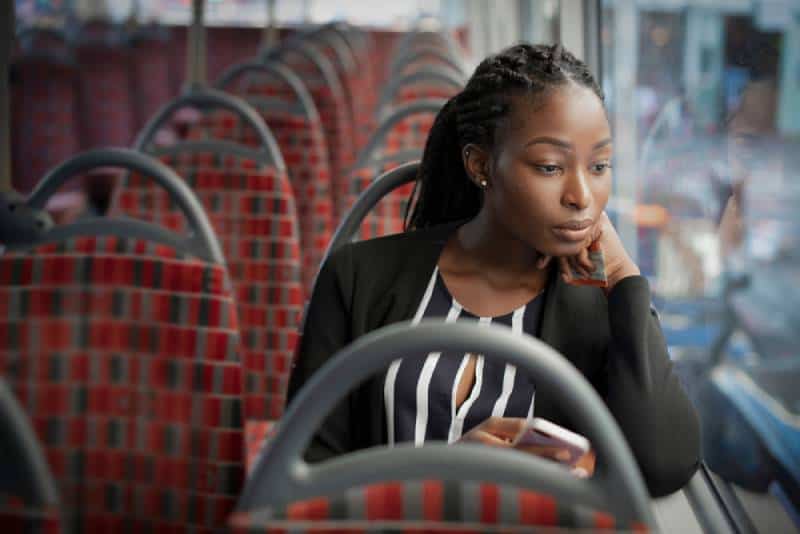 thinking woman sitting in bus and watching throught window