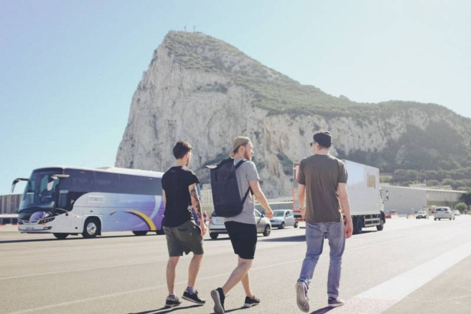 three man walking on the road