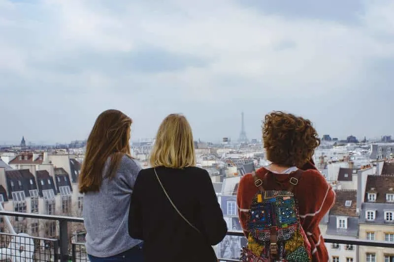 Three young women facing cityscape
