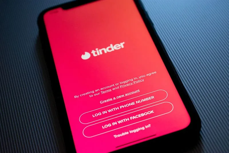 tinder app in pink color shown in the cellphone 