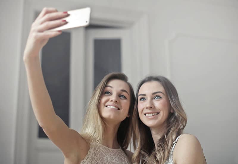 due donne che si fanno un selfie con la fotocamera del cellulare