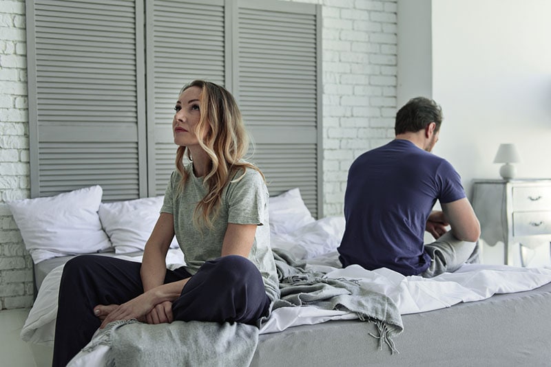 casal infeliz sentado na cama