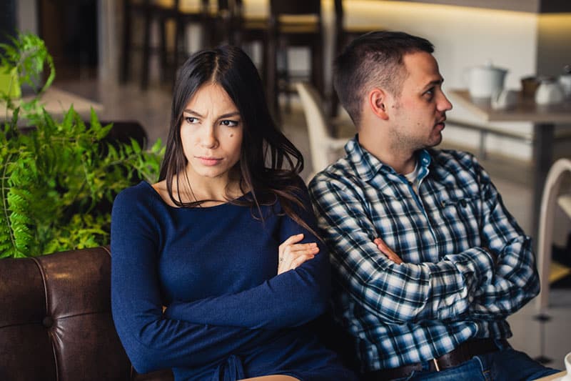 unhappy couple sitting on the couch