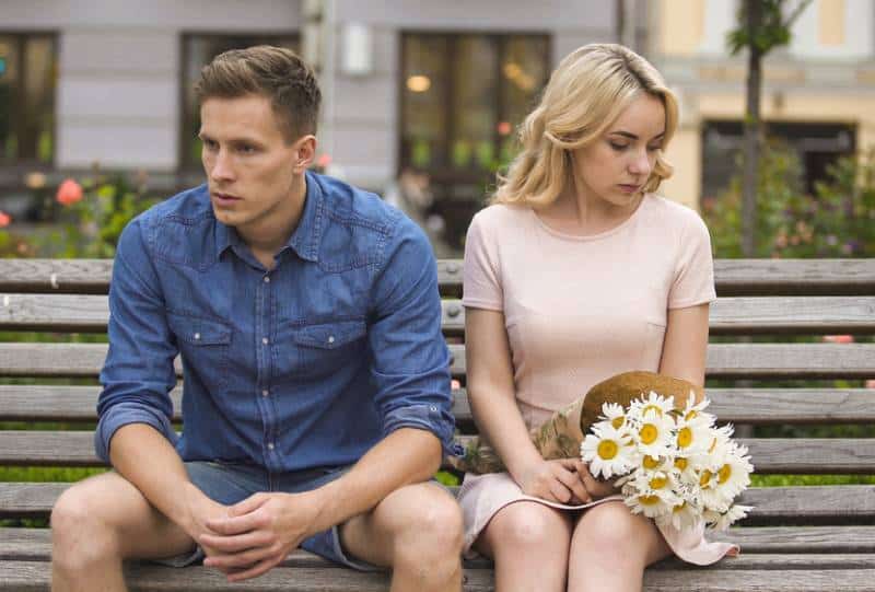 unhappy couple sitting on the park chair