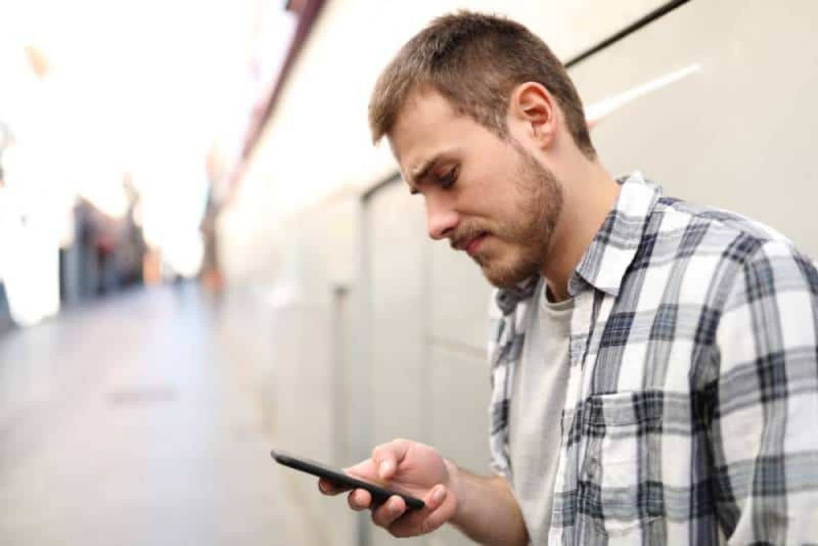 unhappy man texting on his phone