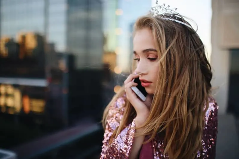 woman with a crown answering a phone 