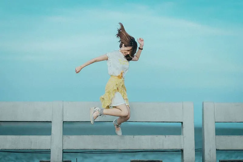 woman in yellow and white dress jump shot