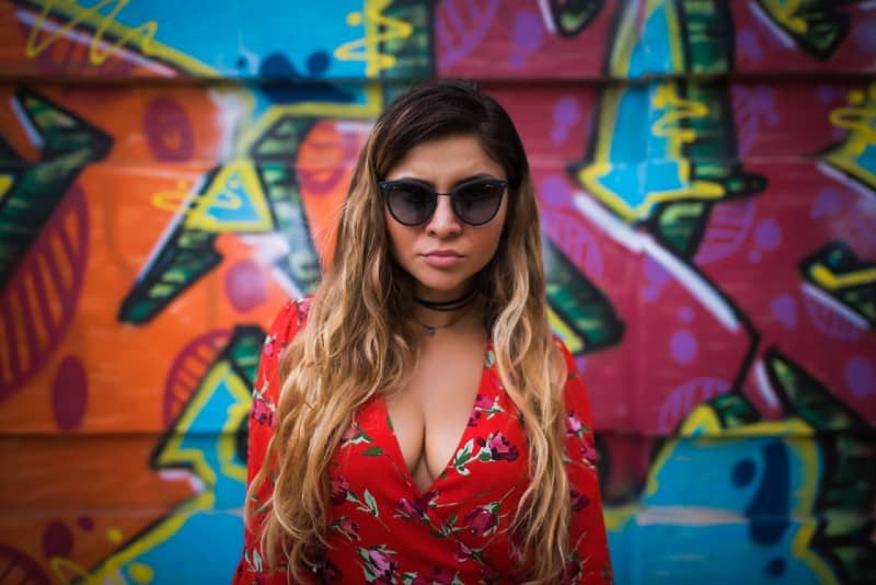 woman wearing black sunglasses in front graffiti