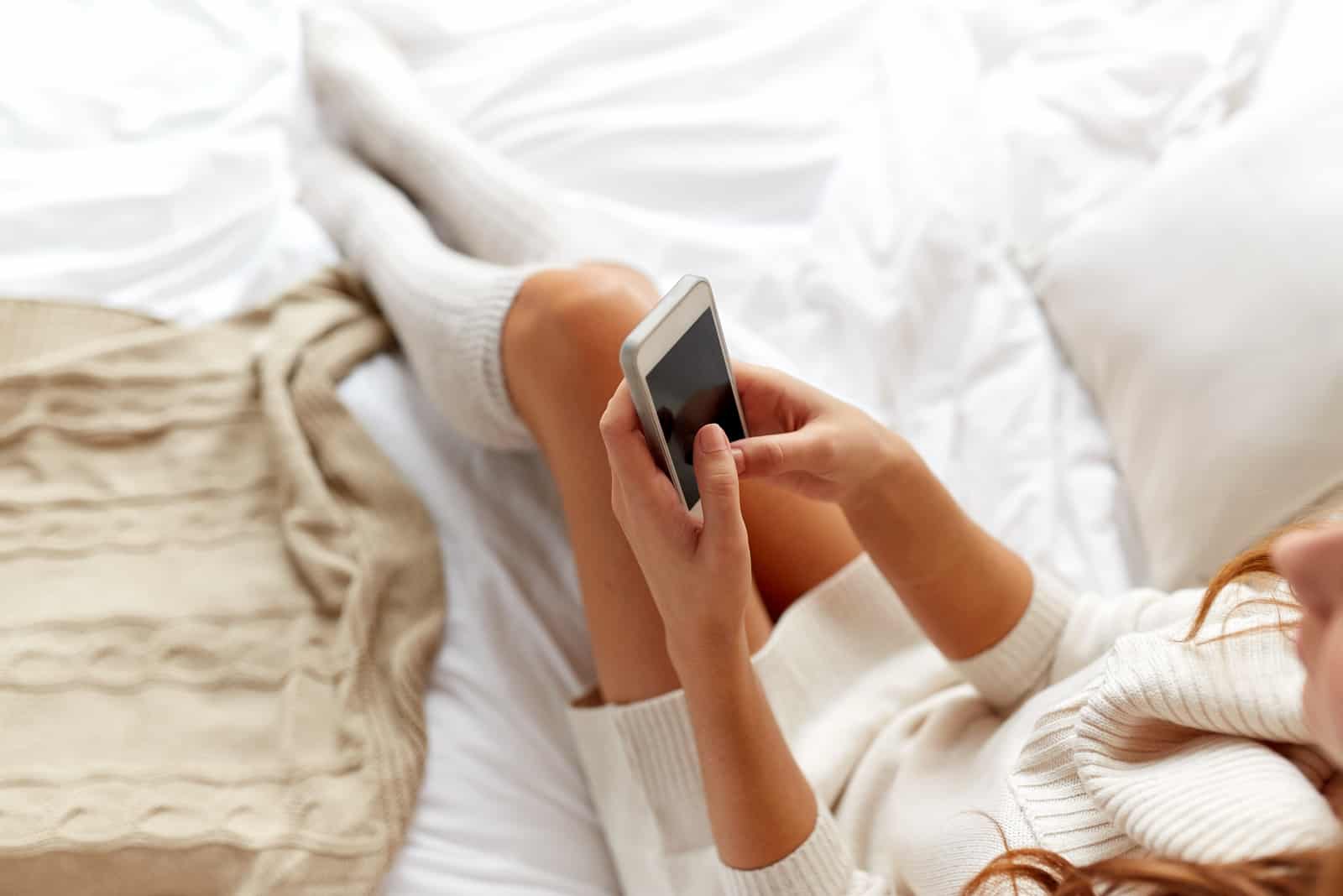 woman sitting in bed and key on the phone