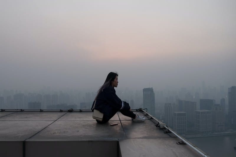 woman sitting on rooftop and thinking