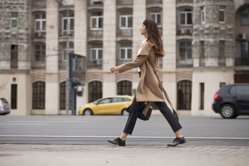 woman walking on sidewalk with a bag