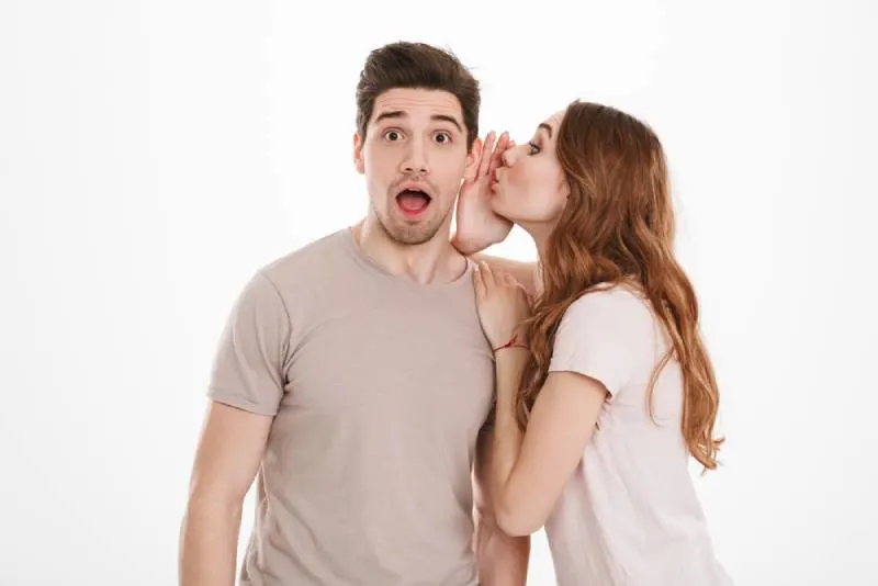 woman whispering to man's ear