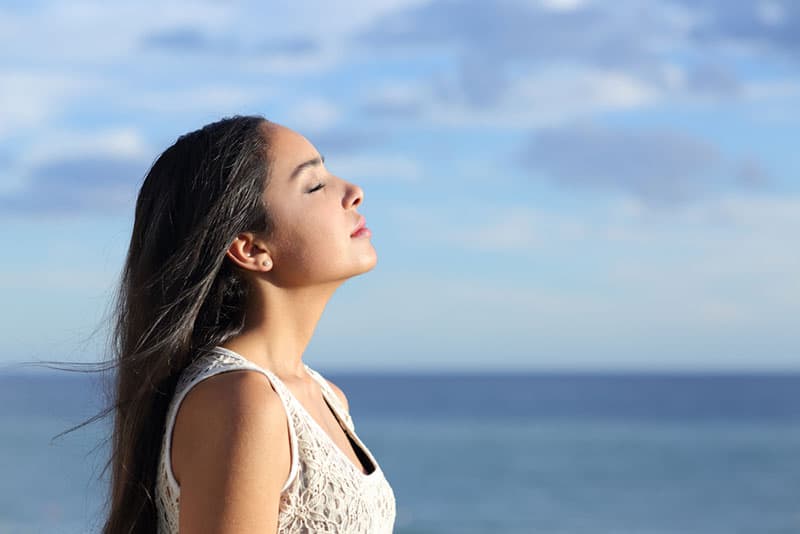 woman with closed eyes breathing deeply