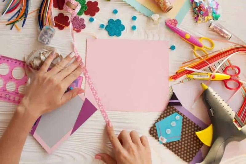 woman's hands making scrapbook with paper