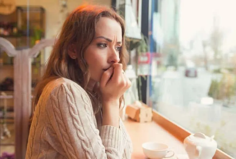 worried woman watching throught window at coffe bar
