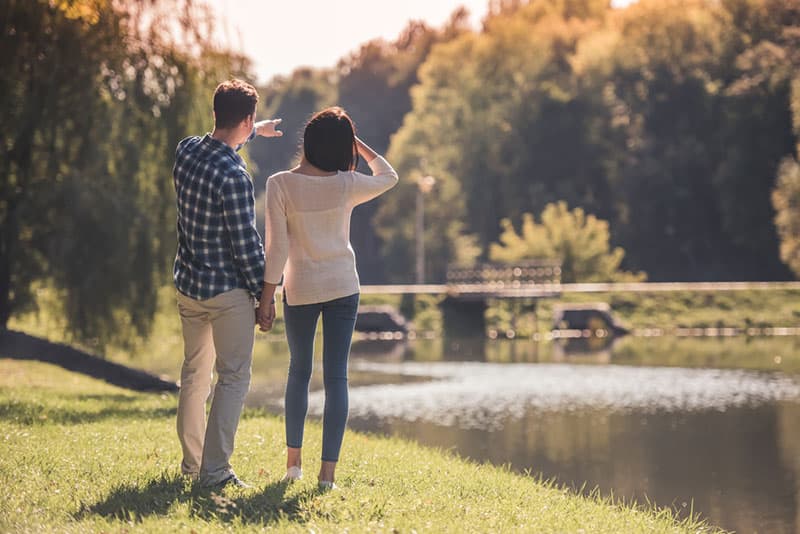 young couple standing by the lake