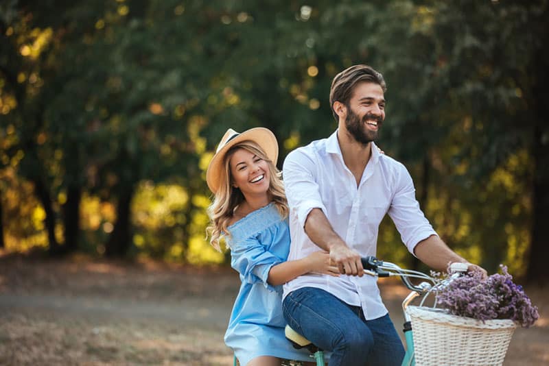 jovem casal feliz a andar de bicicleta