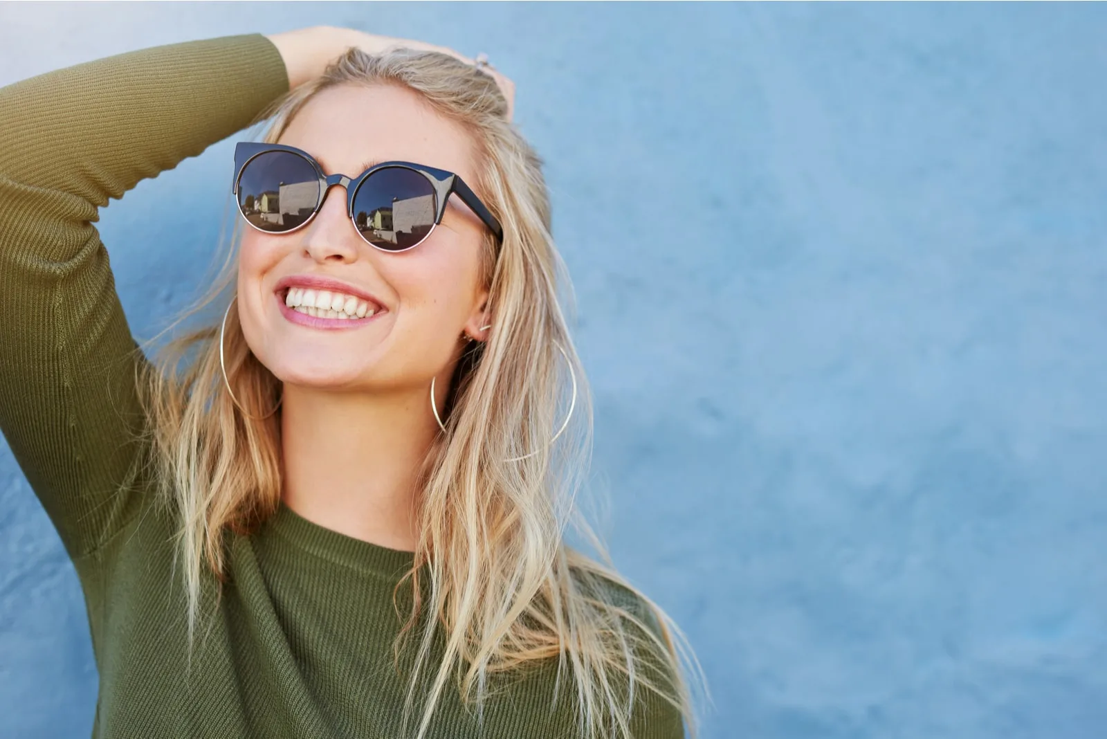 young woman in sunglasses smiling