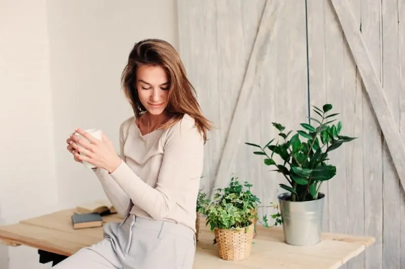 young woman relaxing at home with cup of coffee