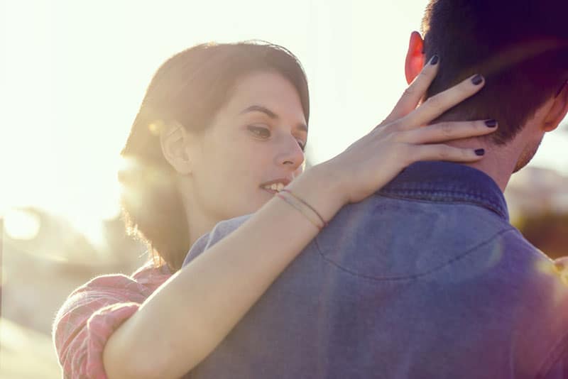 young woman touching man neck