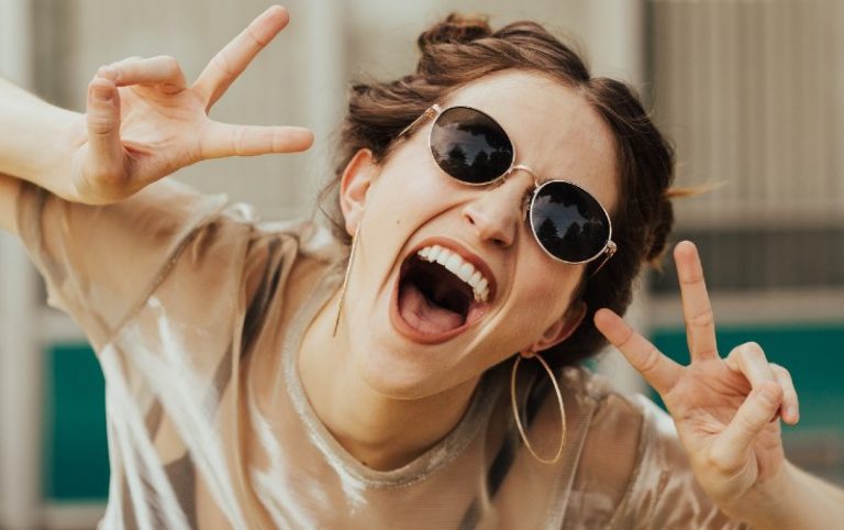 Portrait of a funny ypung woman with sunglasses and her mouth opened