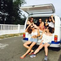 five women sitting in back of van