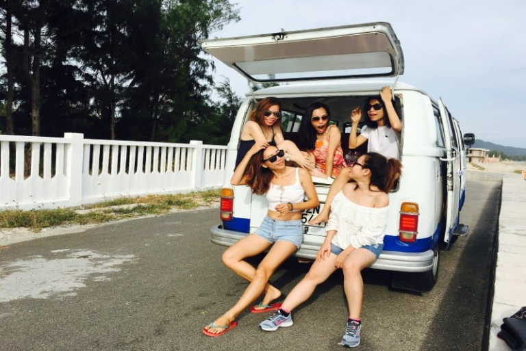 five women sitting in back of van