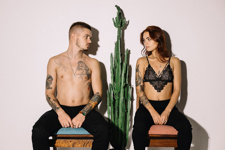 couple sitting beside cactus plant