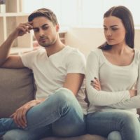 couple in argue sitting on sofa in silence