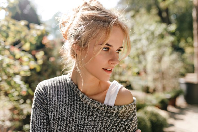 young blonde woman standing outside