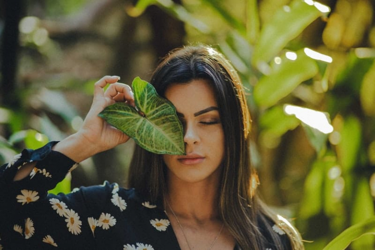 woman covering face with a leaf