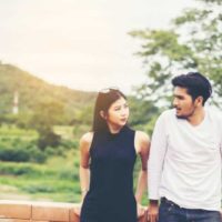 couple leaning on fence outside and looking at each other