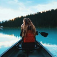 blonde woman with backpack riding on boat