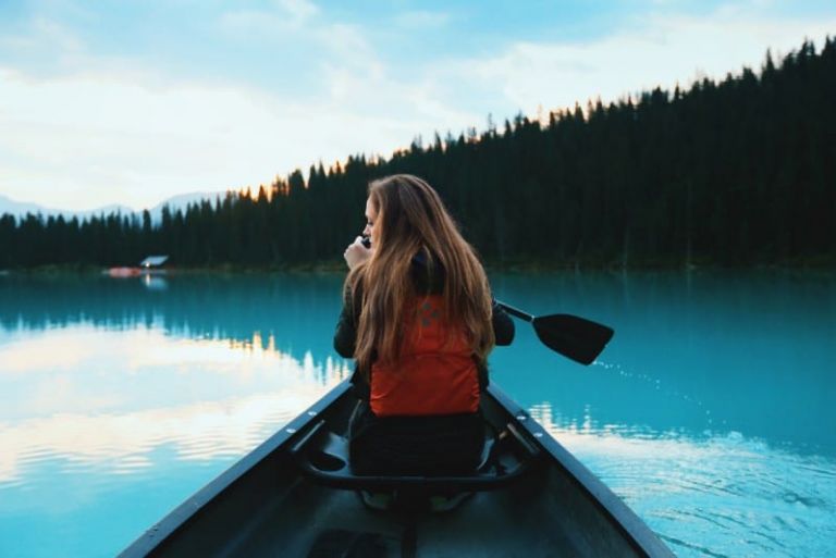 blonde woman with backpack riding on boat