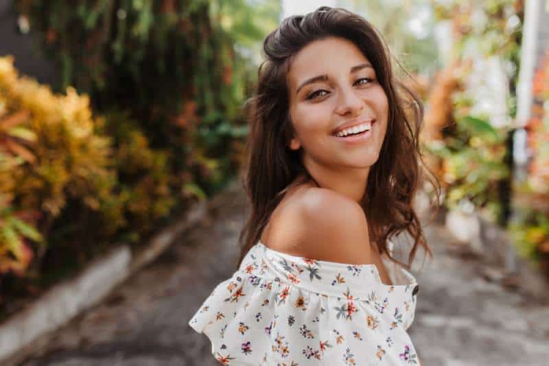 Closeup portrait of tanned woman in light blouse