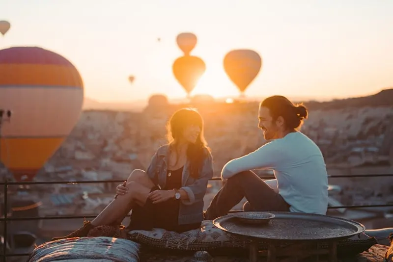 Couple on a date at the rooftop viewing hot air balloons