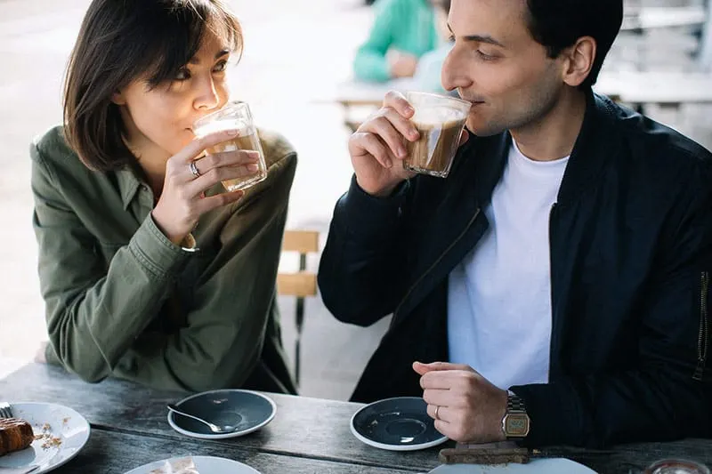 Couple drinking coffee while gazing at each other