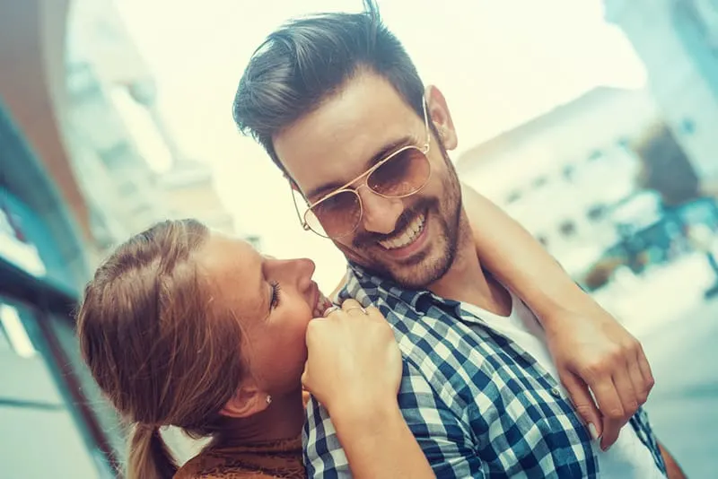 Smiling couple woman hugging man with sunglasses