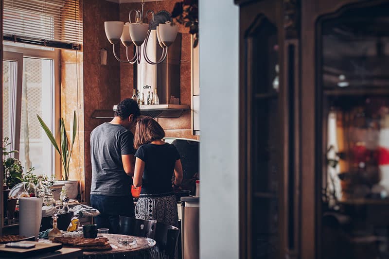 Couple still in pajamas cooking breakfast in the kitchen